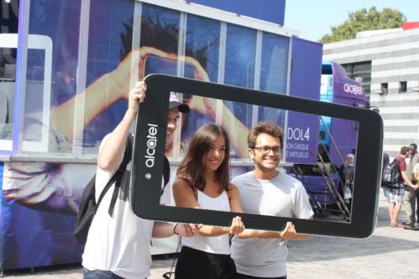 Imagen de un evento, dos personas sostienen un photocol con forma de móvil